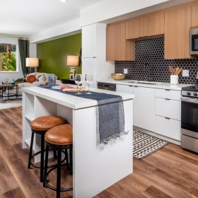 Spacious kitchens with thoughtful details a kitchen with a bar stool and a stove