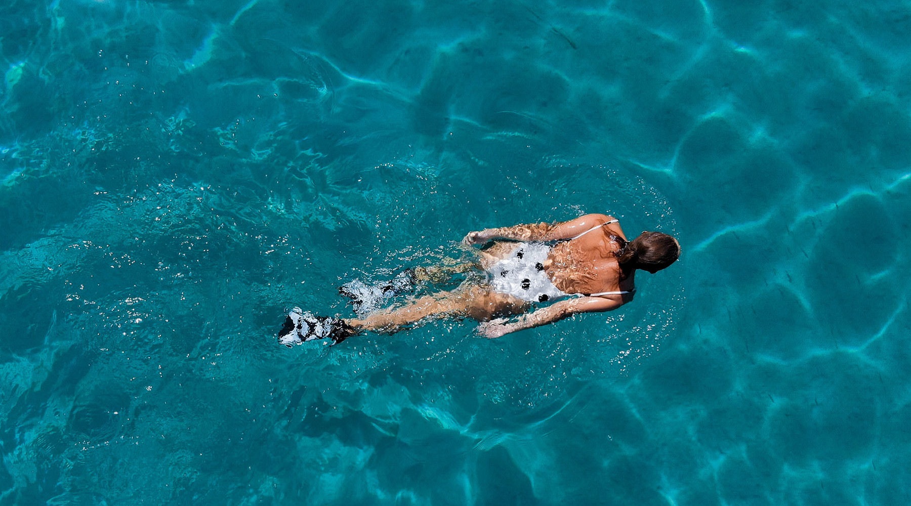 Swimming  woman swimming in a sparkling blue pool